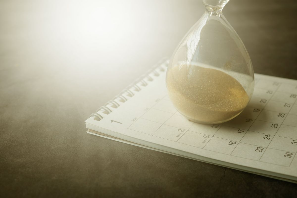 An hourglass resting on a calendar, representing the days a casino withdrawal can take