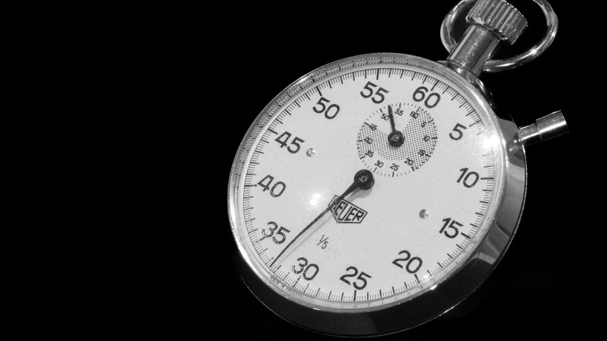 Vintage mechanical stopwatch with a black dial against a dark background, used to time casino withdrawals
