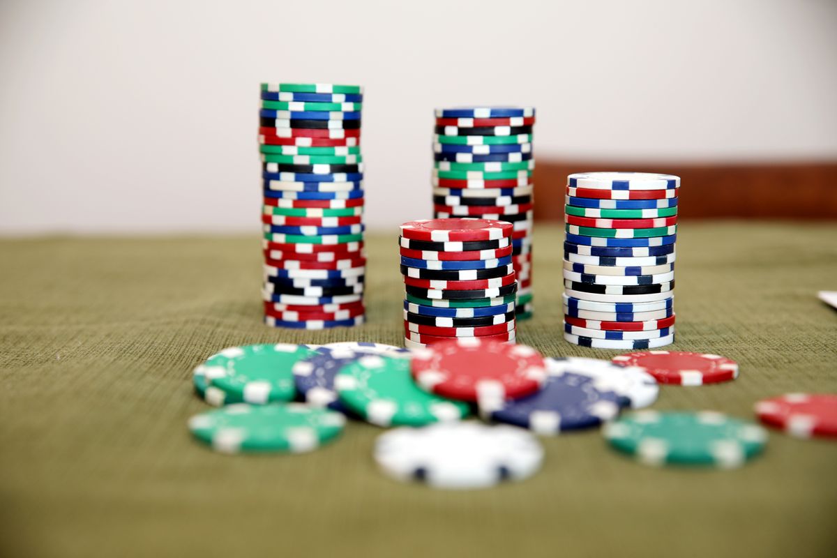 Stacks of colorful poker chips on a green casino table