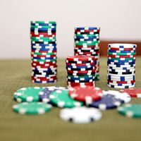 Stacks of colorful poker chips on a green casino table