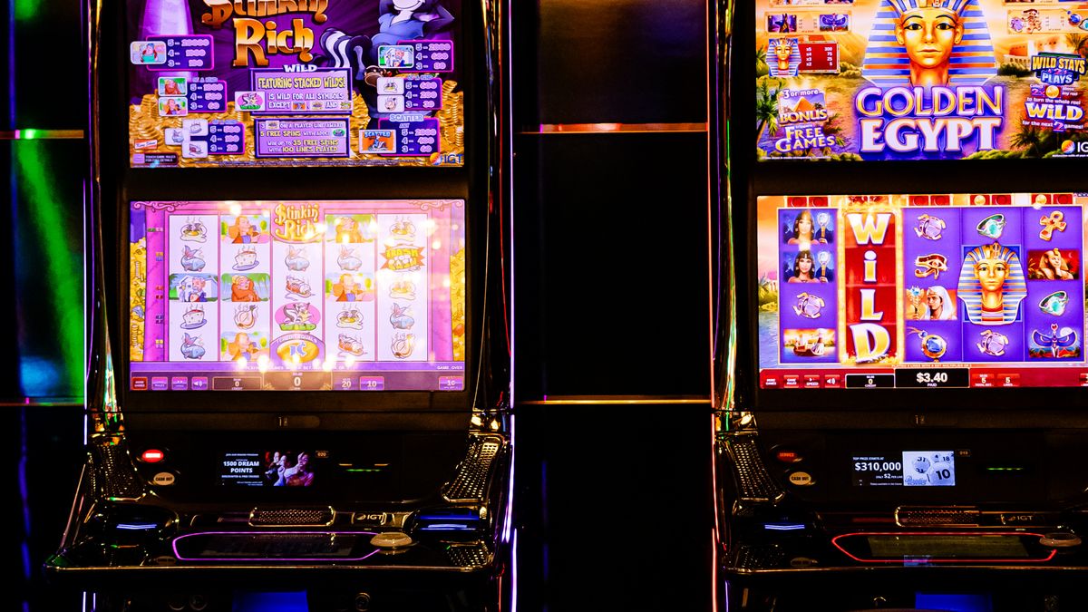 Colorful slot machines lit up inside a casino at night