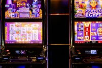 Colorful slot machines lit up inside a casino at night