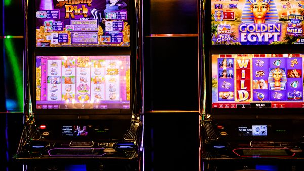 Colorful slot machines lit up inside a casino at night