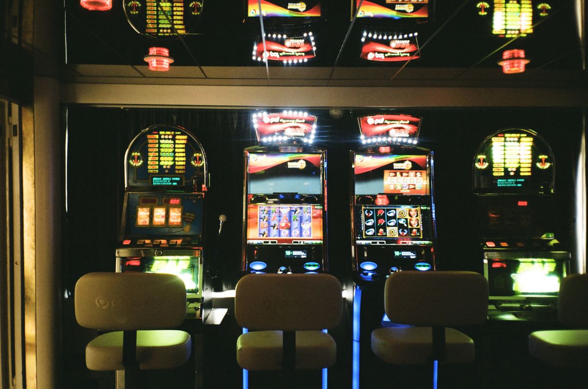 Row of slot machines in a dimly lit casino