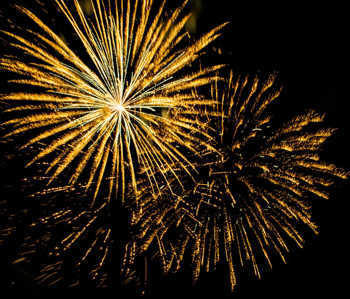 Golden fireworks bursting against a dark night sky