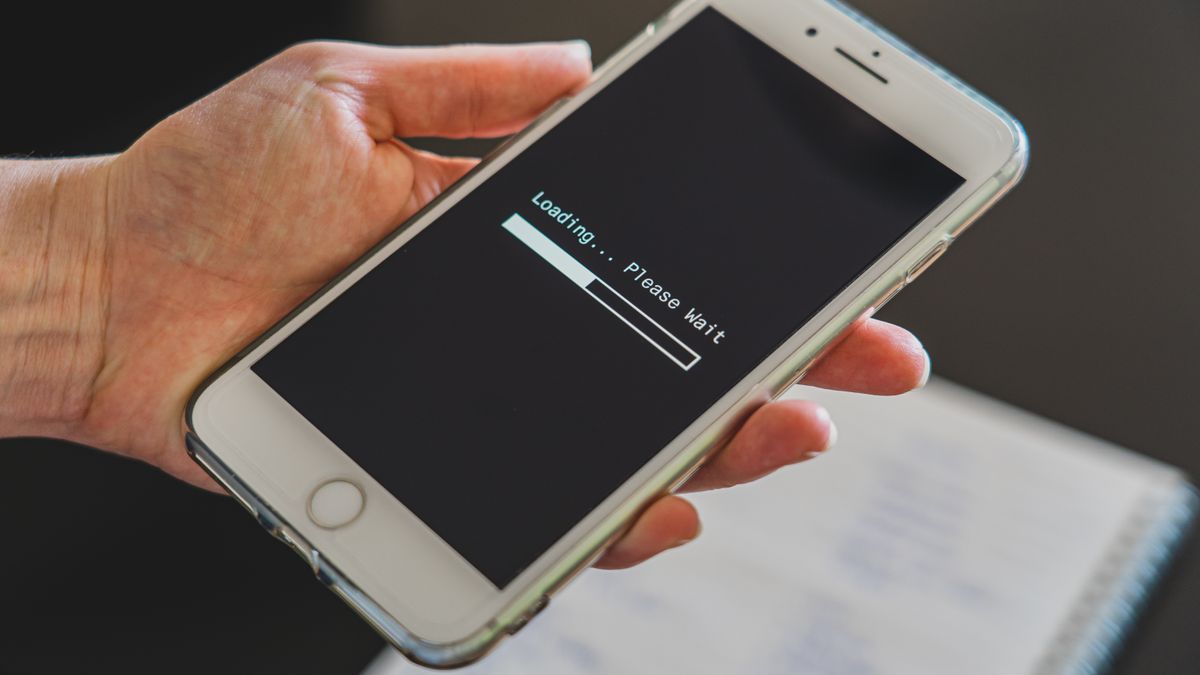Close-up of a hand holding a smartphone with a loading screen displayed