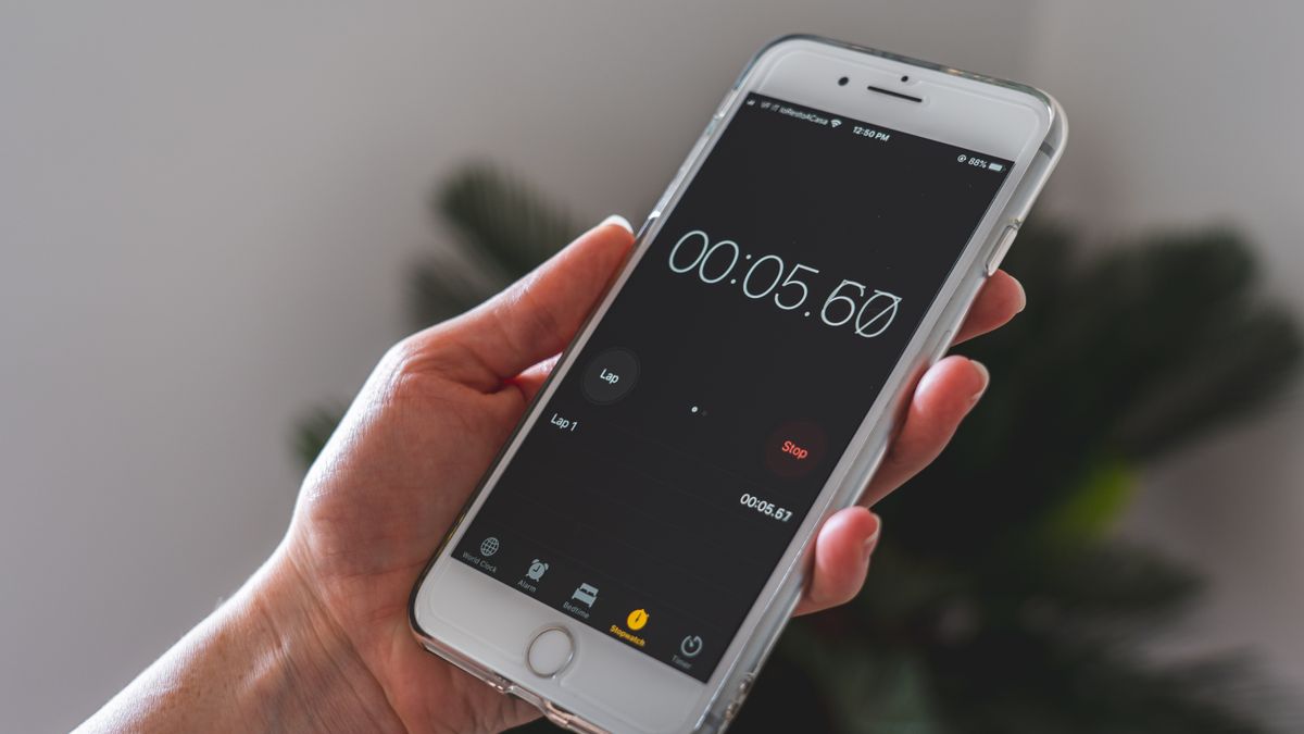Close-up of a hand holding a smartphone with a stopwatch app running
