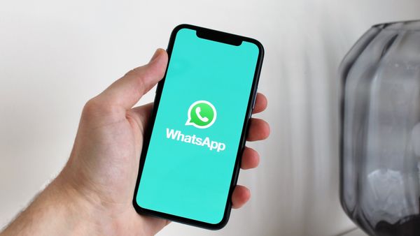 Close-up of a hand holding a smartphone displaying the WhatsApp app screen