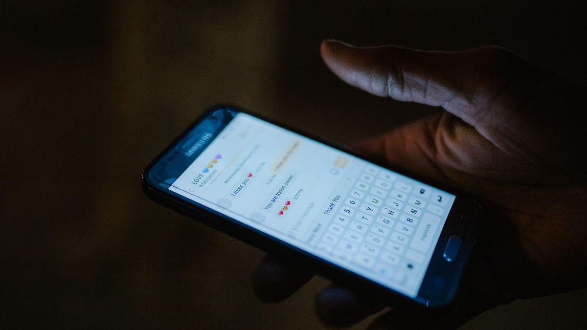 Close-up of a hand holding a smartphone with a messaging app open