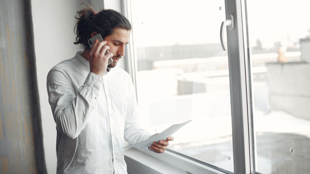 Man checking paperwork over a phone call before signing up to an online casino