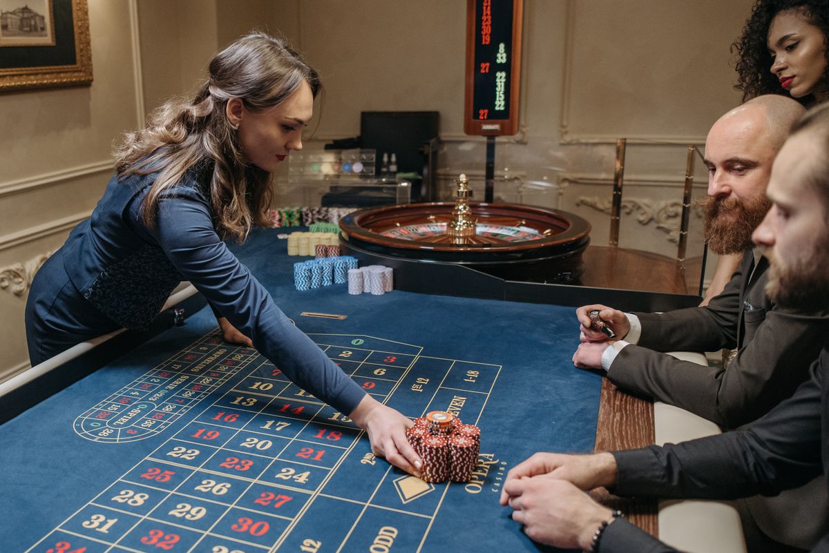 A live dealer running a roulette game at a casino table