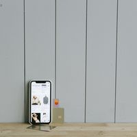 A smartphone beside a credit card on a wooden surface